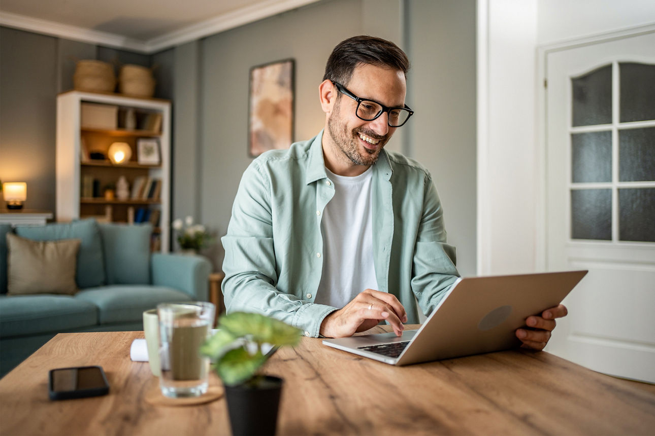 Mann sitzt vor Laptop
