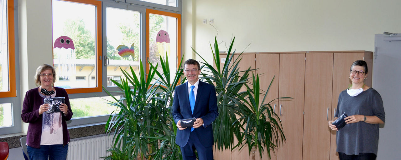 Herbert Schlemmer, Filialleiter in Haßfurt übergibt die Masken an Giesela Schott und Monika Spörlein