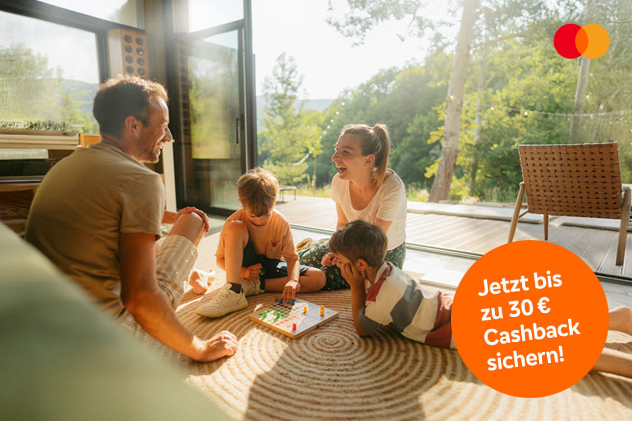 Eine Familie sitzt auf dem Boden und spielt.