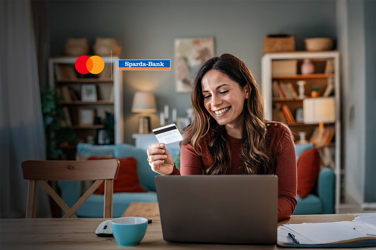 Frau hält lächelnd eine mastercard in der Hand