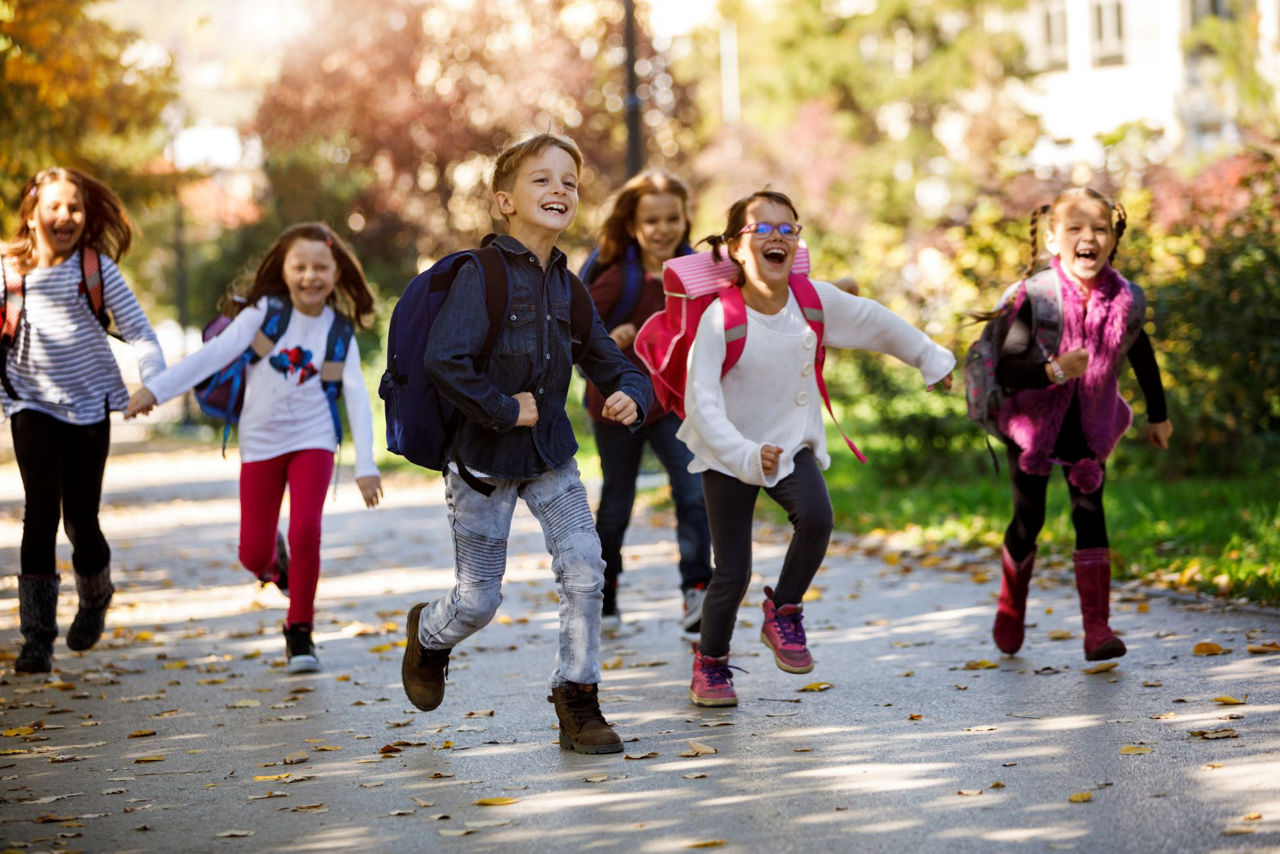 Kinder laufen nach der Schule freudig nach Hause