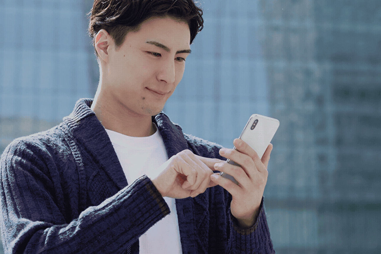 Ein junger Mann schaut auf sein Handy