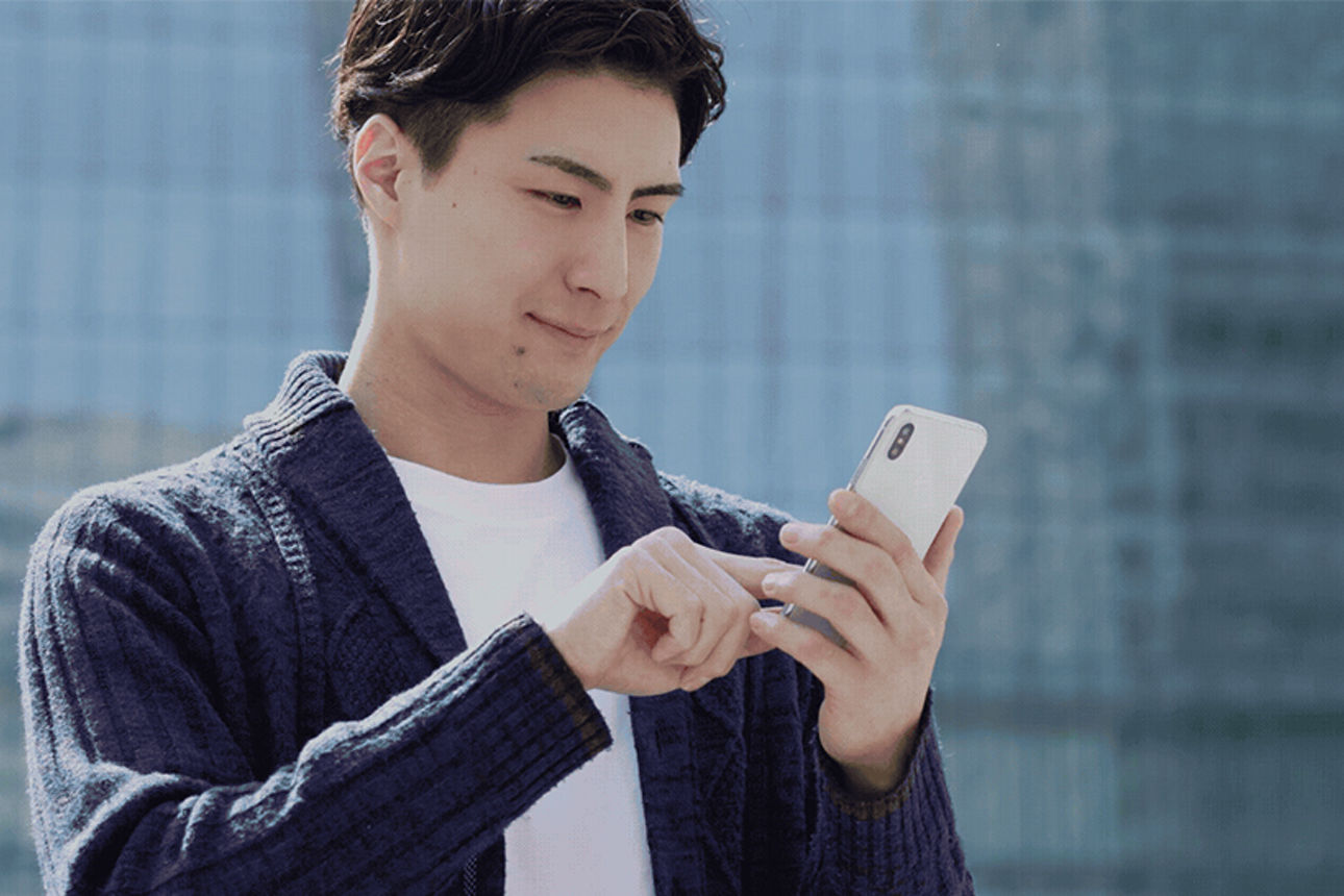 Ein junger Mann schaut auf sein Handy