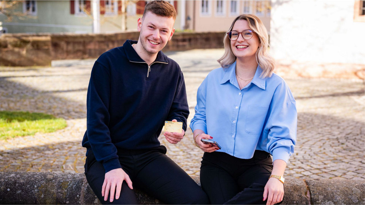 2 Junge Leute die eine Kreditkarte in die Kamera halten