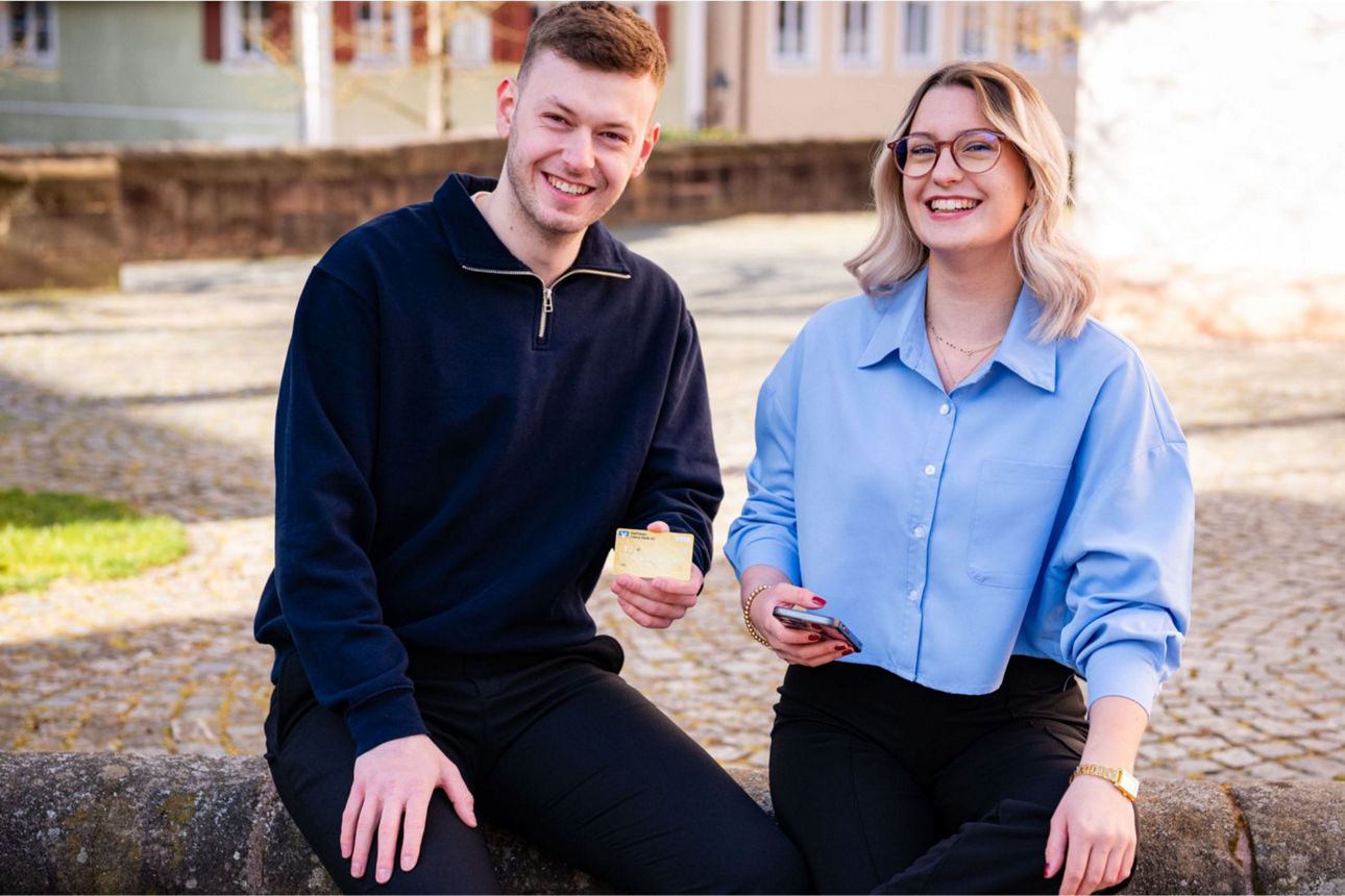 2 Junge Leute die eine Kreditkarte in die Kamera halten