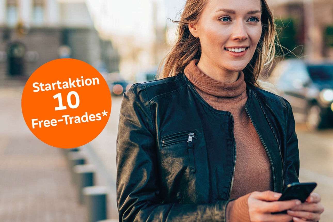 Junge Frau mit Smartphone in der Hand steht auf der Straße und lächelt