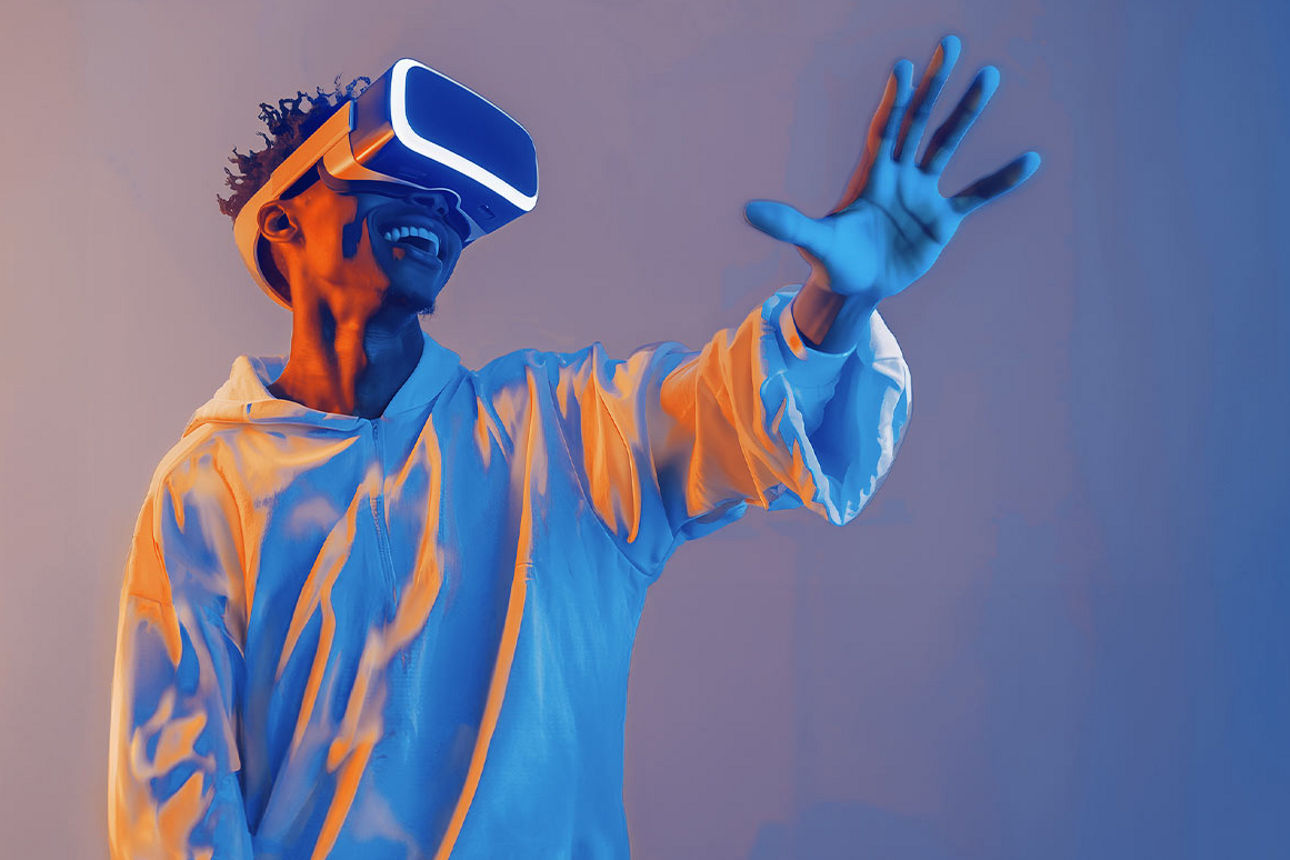Ein junger Mann mit VR-Brille hält seine Hand nach vorne ausgestreckt und lächelt
