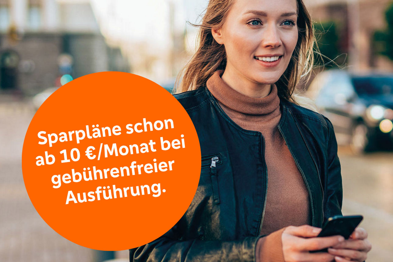 Junge Frau mit Smartphone in der Hand steht auf der Straße und lächelt