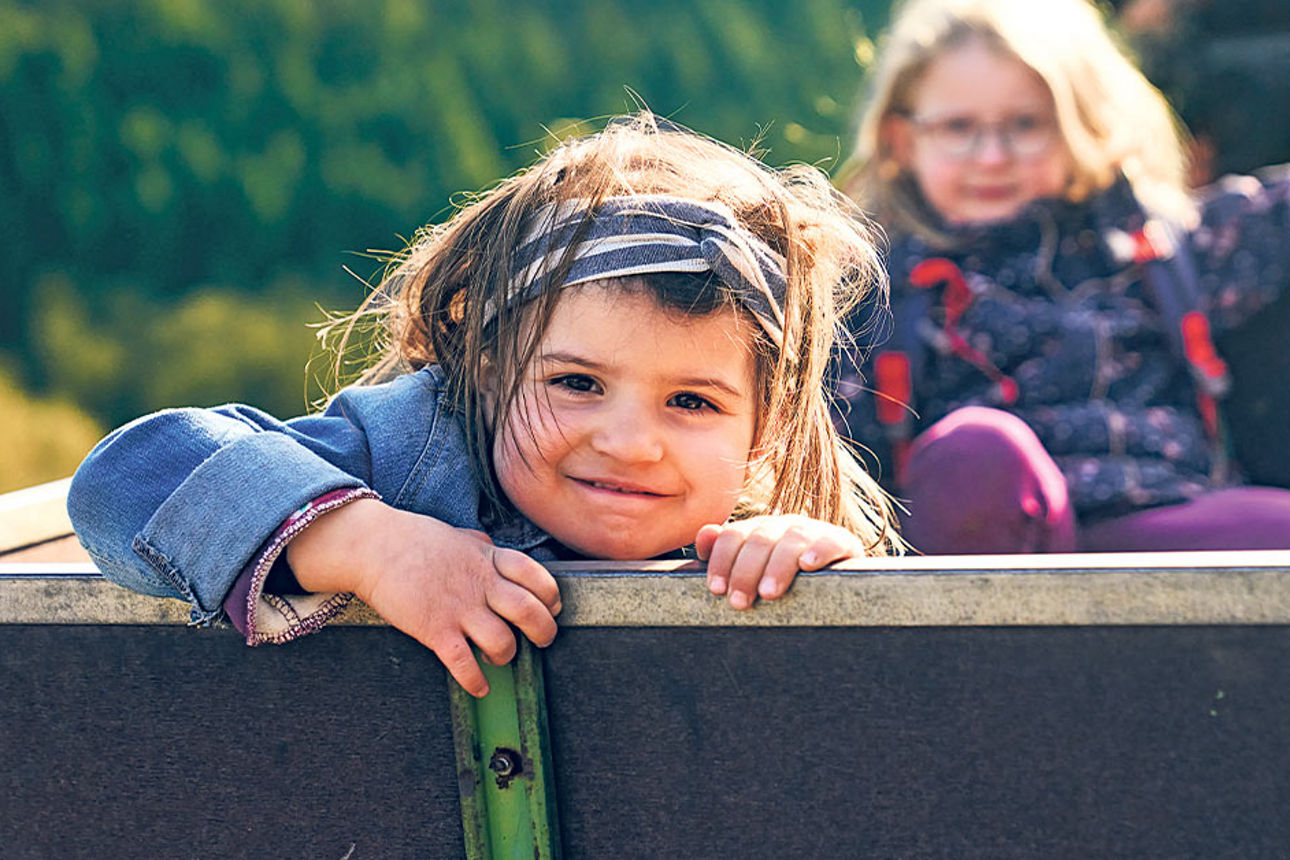 Zwei kleine Mädchen sitzen im Anhänger.