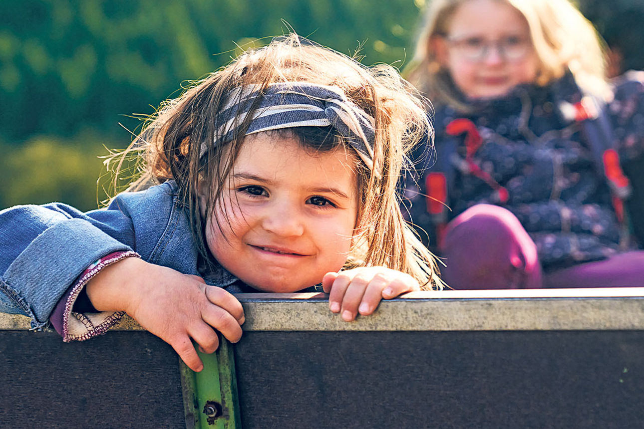 Zwei Kinder genießen die Natur – lachend und neugierig bei einem Ausflug im Grünen