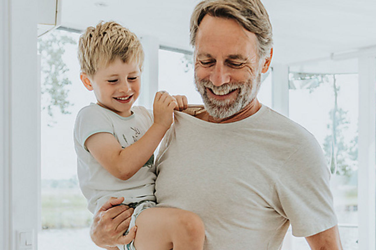 Mann hält einen kleinen Jungen auf seinen Armen