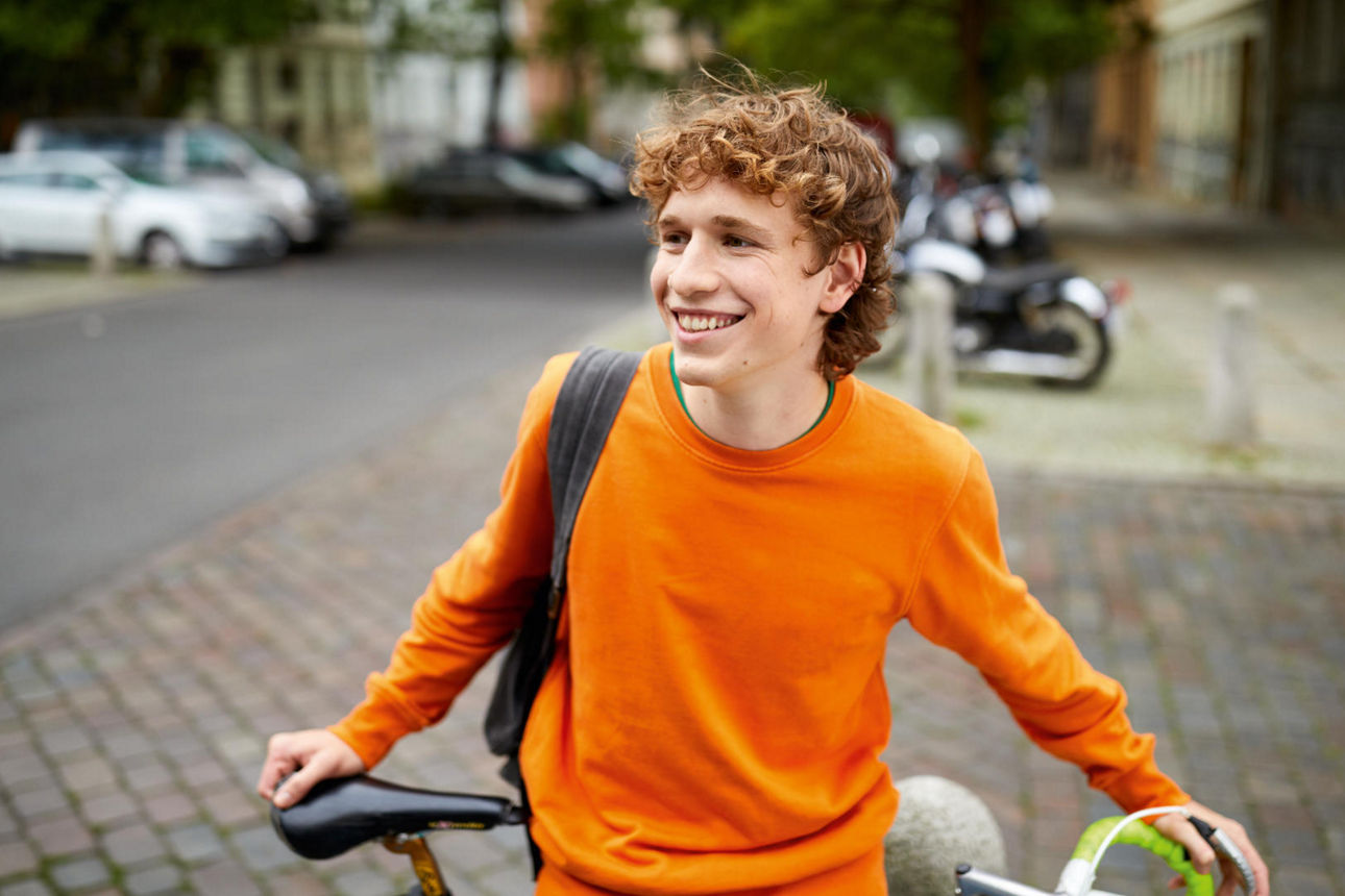 Jugendlicher hält sein Fahrrad
