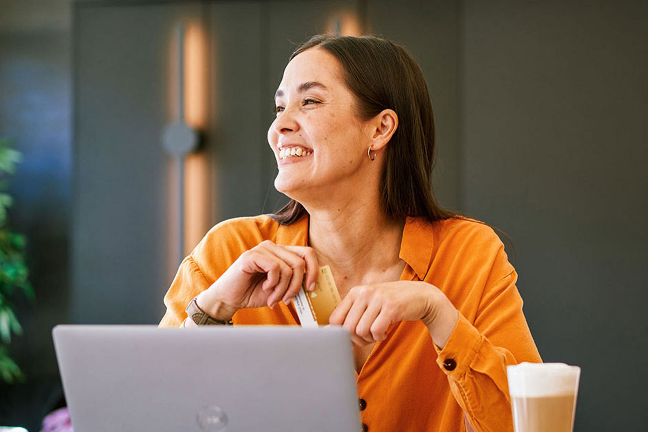 Frau sitz lächelnd am Laptop