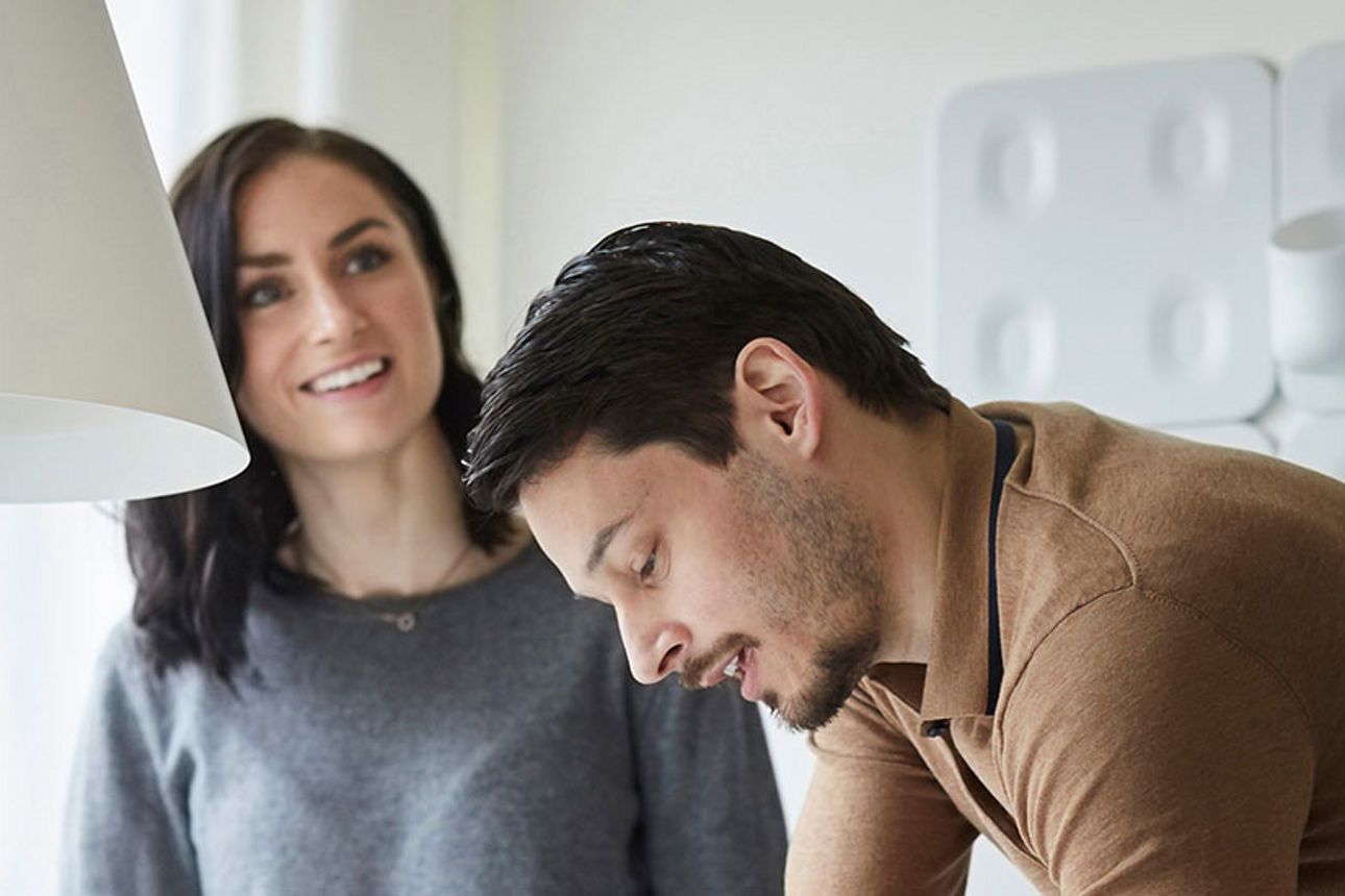 Frau und Mann sichten zusammen Unterlagen am Tisch