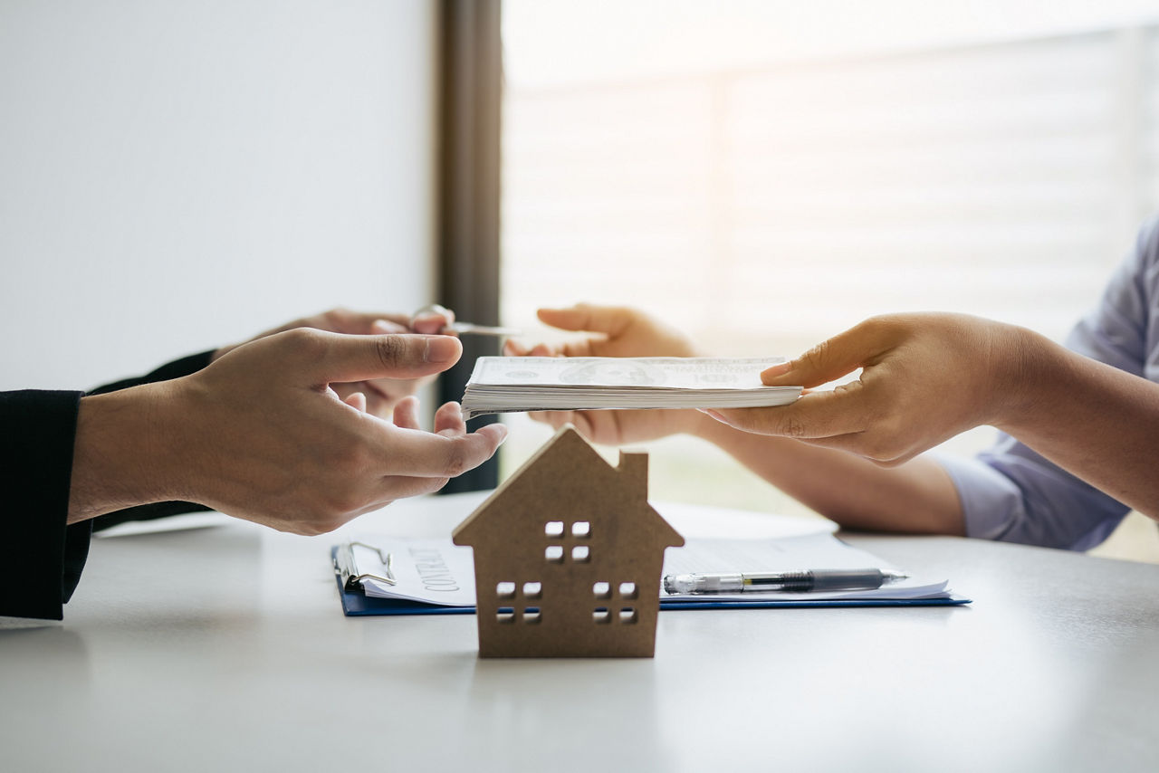 Austausch zwischen Immobilienmakler und Immobilieninvestor und Übergabe von Dokumenten