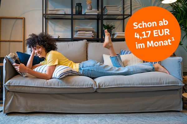 Frau liest Zeitung auf der Couch