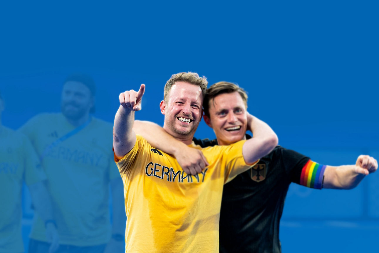 Zwei Fußballspieler in gelbem und schwarzem Trikot jubeln gemeinsam vor blauem Hintergrund.
