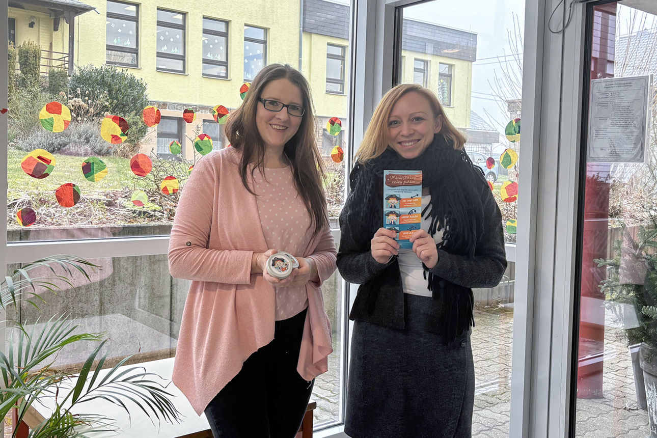 Stellvertretende Kita-Leiterin Marina Winter nimmt die Milchzahndosen und Flyer von Jennifer Einolf entgegen