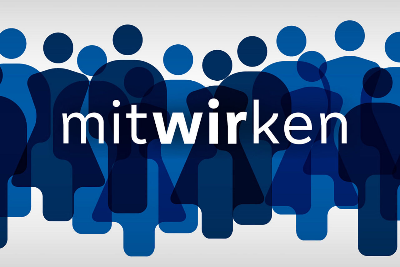 Eine junge Frau sitzt vor einem Computer und reckt freudig die Faust in die Luft