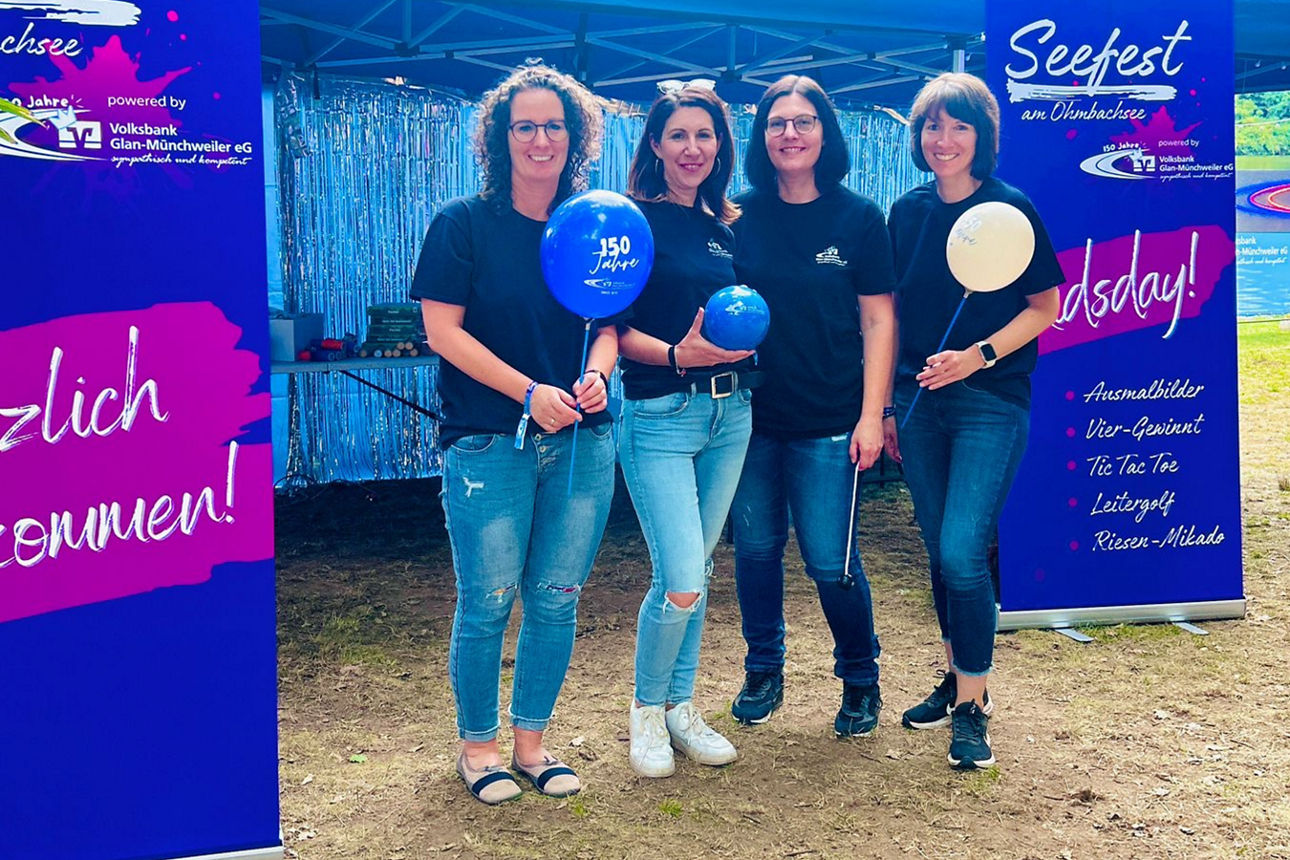 Mitarbeiterinnen unserer Volksbank, die vor einem Stand stehen