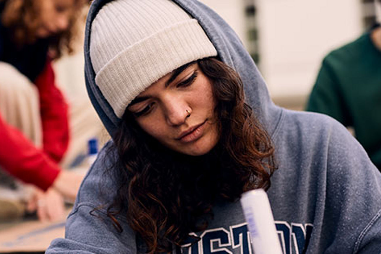 Drei junge Leute malen mit den Stiften auf dem Boden