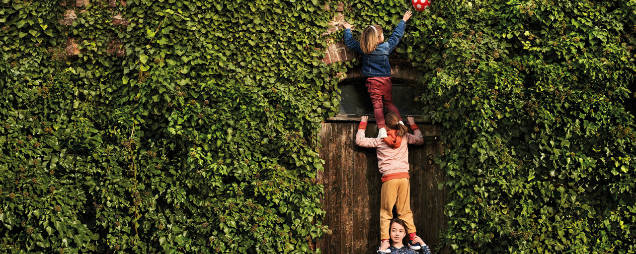 Kinder stehen im Garten auf den Schultern der anderen Kinder