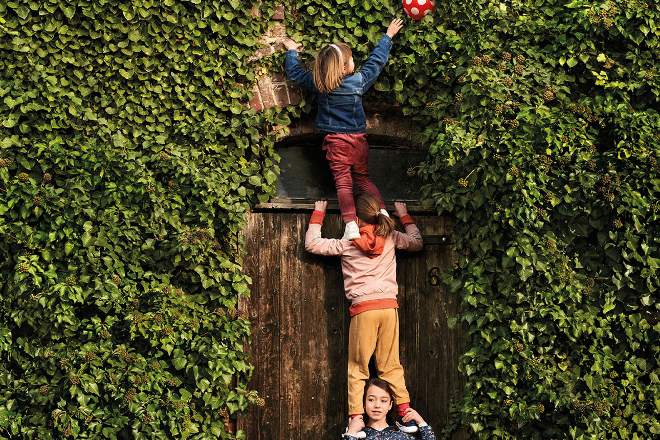 Kinder stehen im Garten auf den Schultern der anderen Kinder