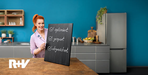 Enie van de Meiklokjes hält ein Schild mit Vorteilen des Versicherungs-Checks