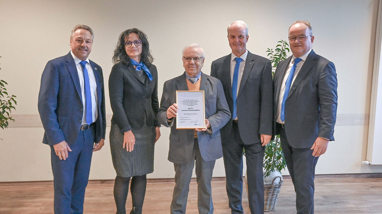 Alfons Müller (Mitte) hält seine Ehrenurkunde in den Händen. Neben ihm stehen die Mitglieder von Vorstand und Aufsichtsrat.
