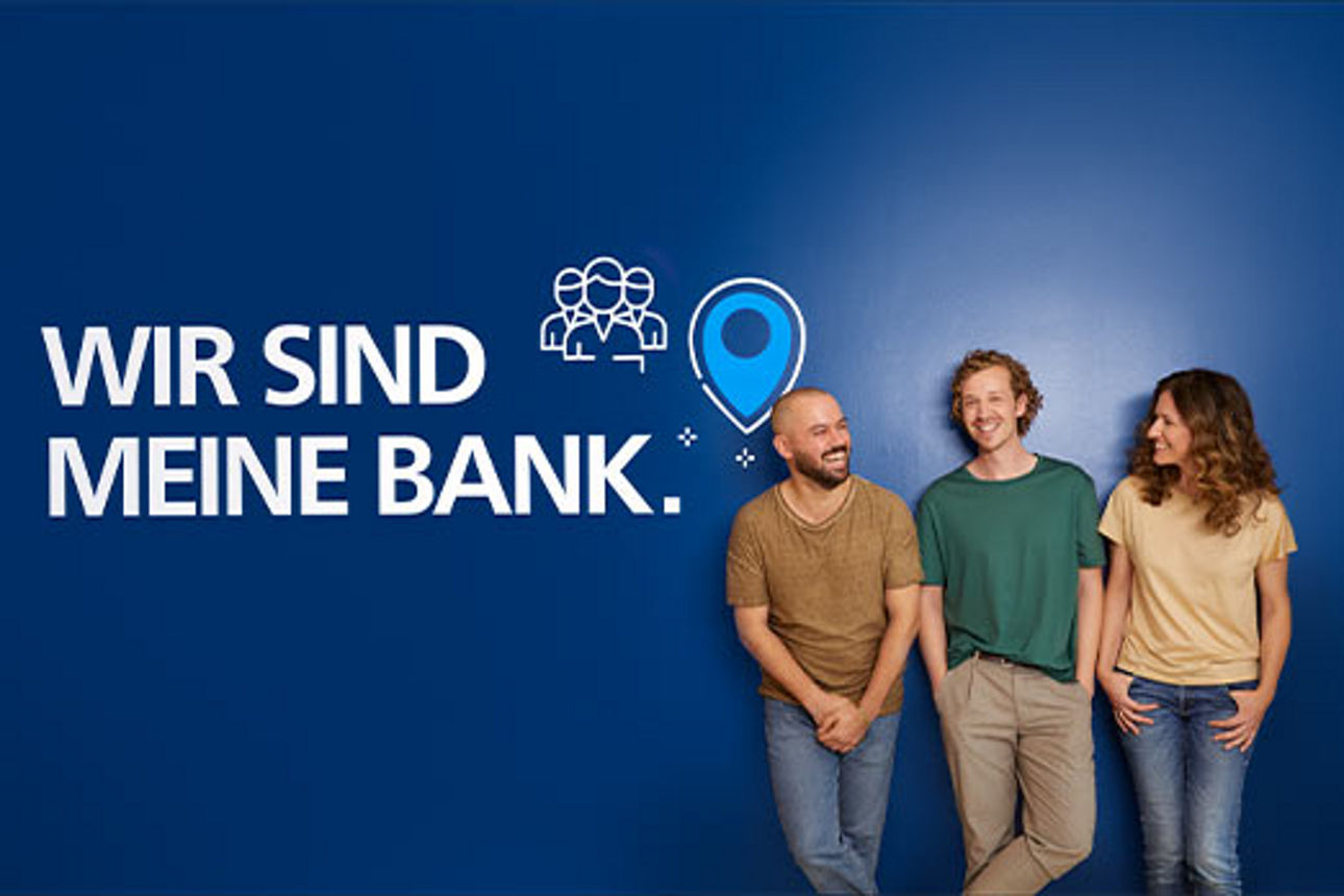 Drei lachende Menschen stehen vor einer blauen Wand mit dem Schriftzug „Wir sind meine Bank.”