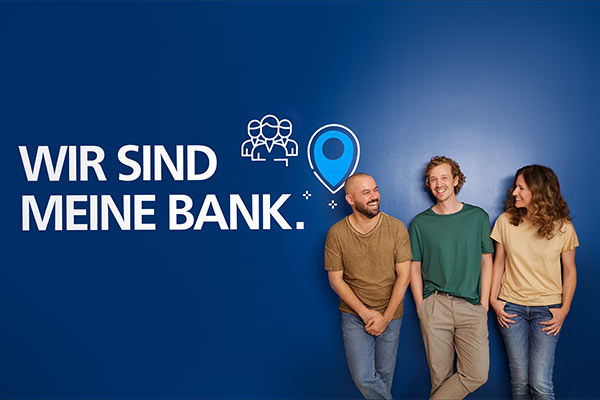 Drei lachende Menschen stehen vor einer blauen Wand mit dem Schriftzug „Wir sind meine Bank.”