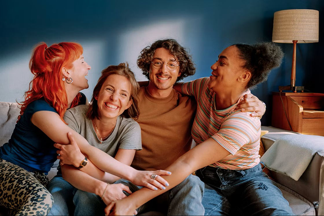Junge Leute sitzen auf dem Sofa und freuen sich