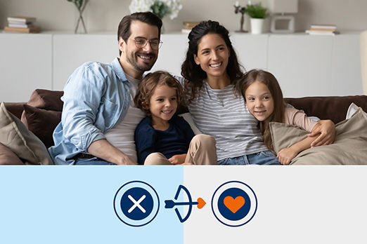 Eine junge Familie sitzt lächelnd auf dem Sofa