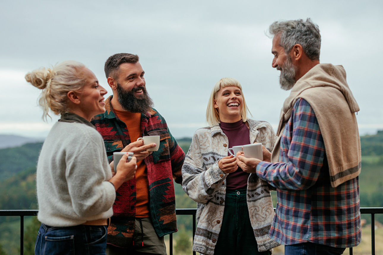 Vier lächelnde Personen in Freizeitkleidung 