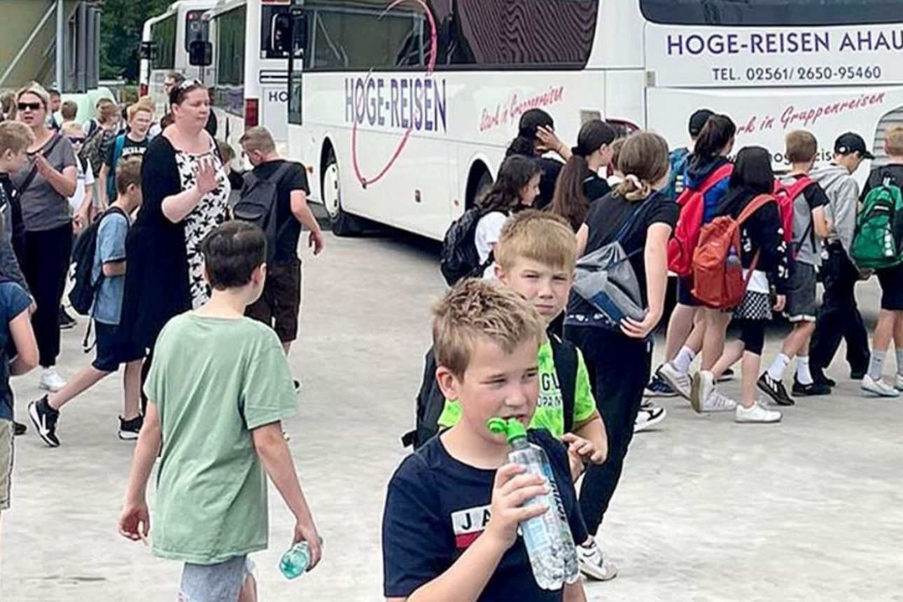 Ankunft der Ausflugsgruppe: Zahlreiche Kinder und Begleitpersonen steigen auf einem Hof aus den Reisebussen aus