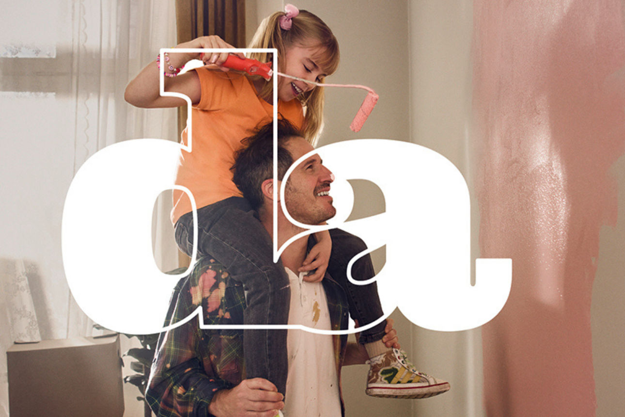 Vater und Tochter streichen gemeinsam ein Zimmer und haben Spaß dabei.