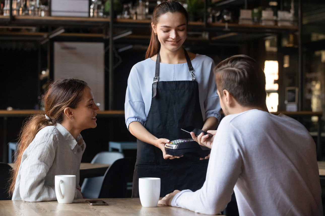 Mann und Frau zahlen per Samsung Pay im Cafe