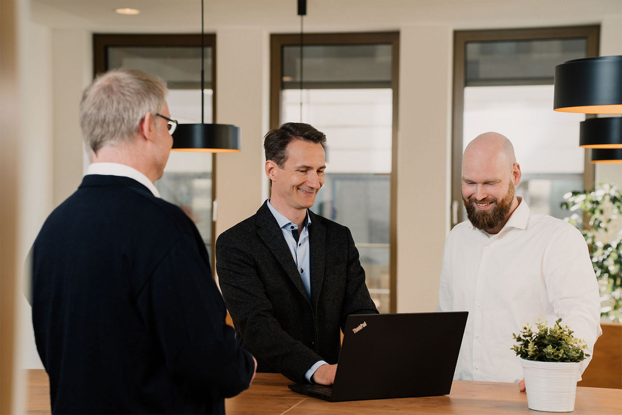 Teammeeting dreier Mitarbeiter der Bank
