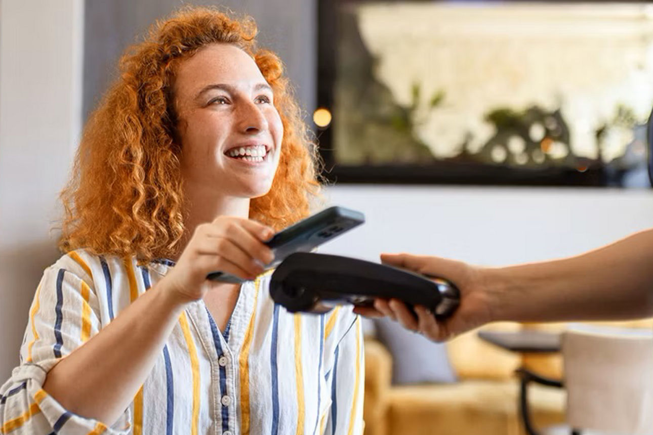 Frau bezahlt bei einem Kellner mit der digitalen girocard