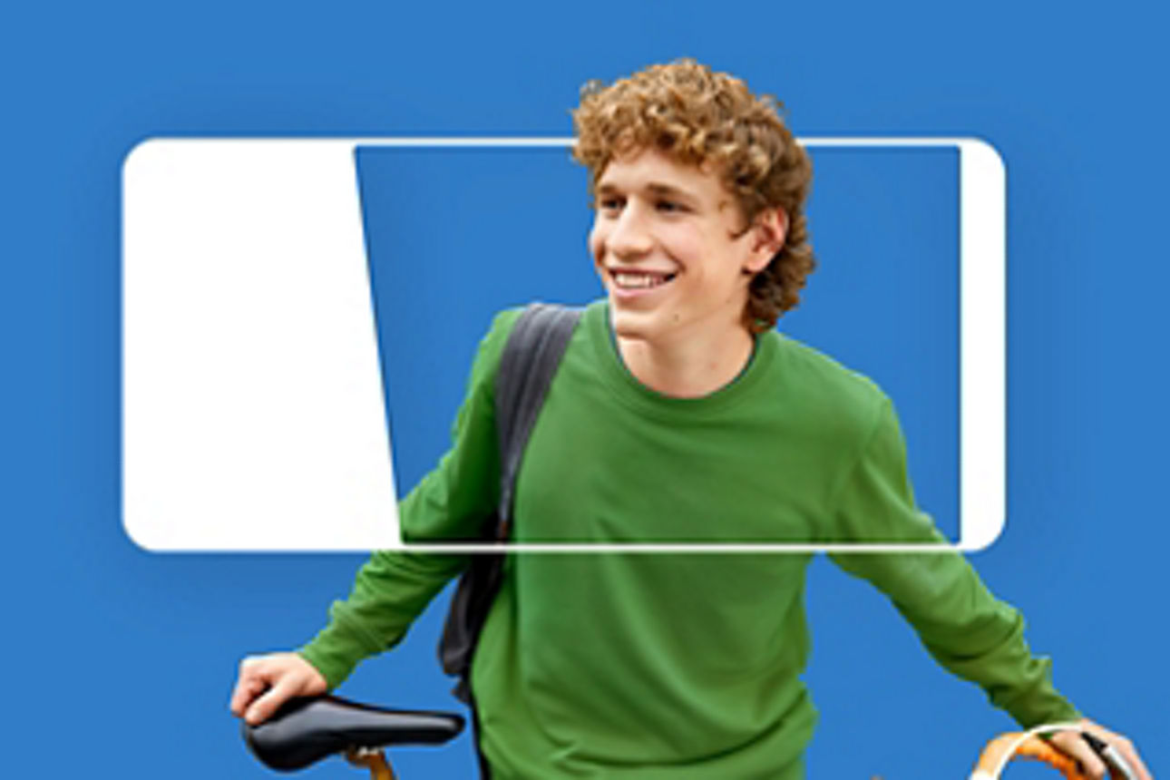 Lachender Mann mit grünem Pullover und Fahrrad in der Hand