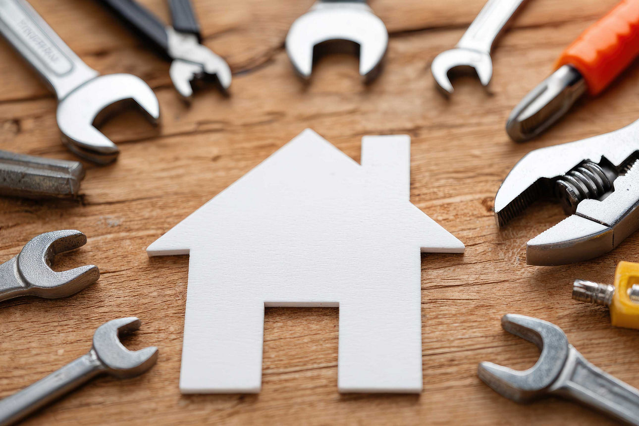 Verschiedene Werkzeuge sind um ein symbolisches Haus angeordnet