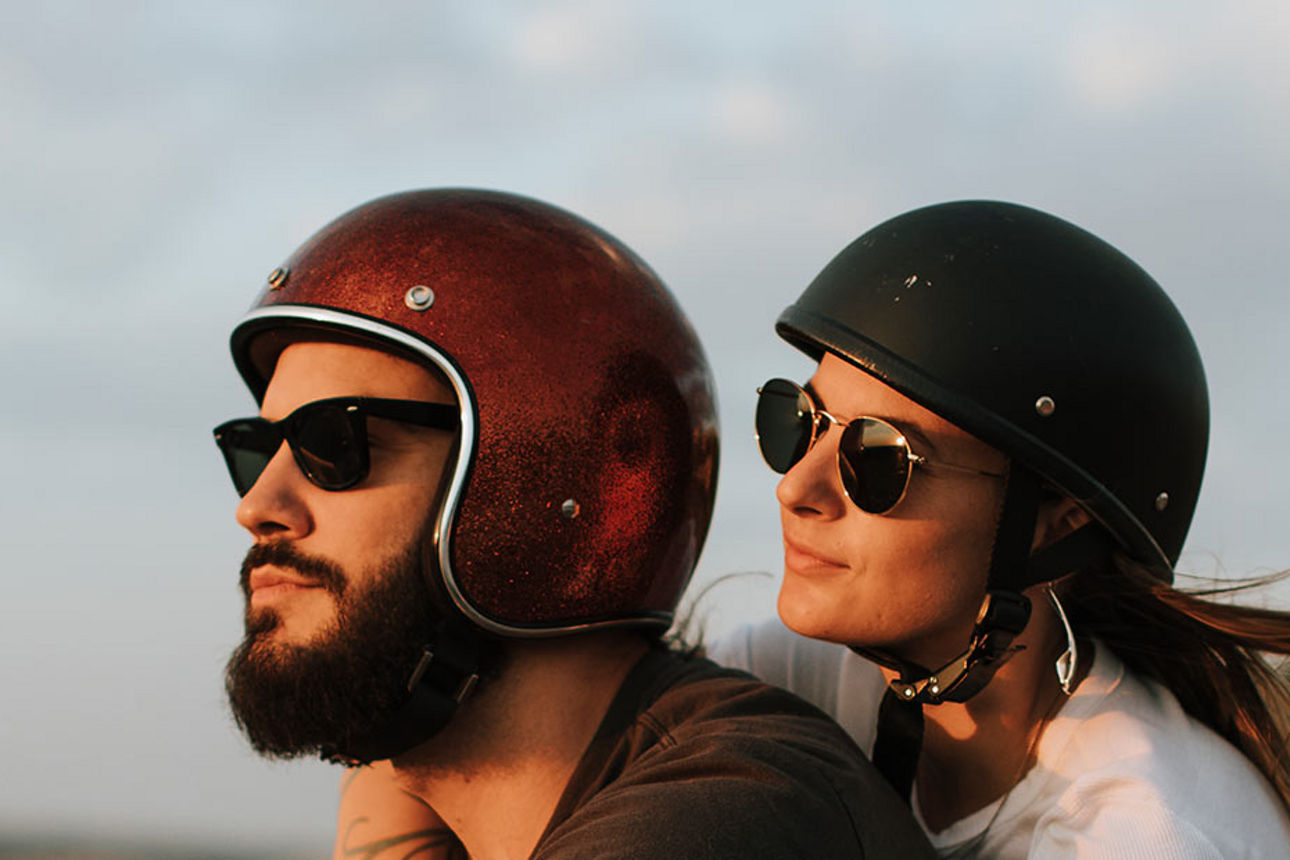 Mann und Fraumit Helm auf einem Motorrad