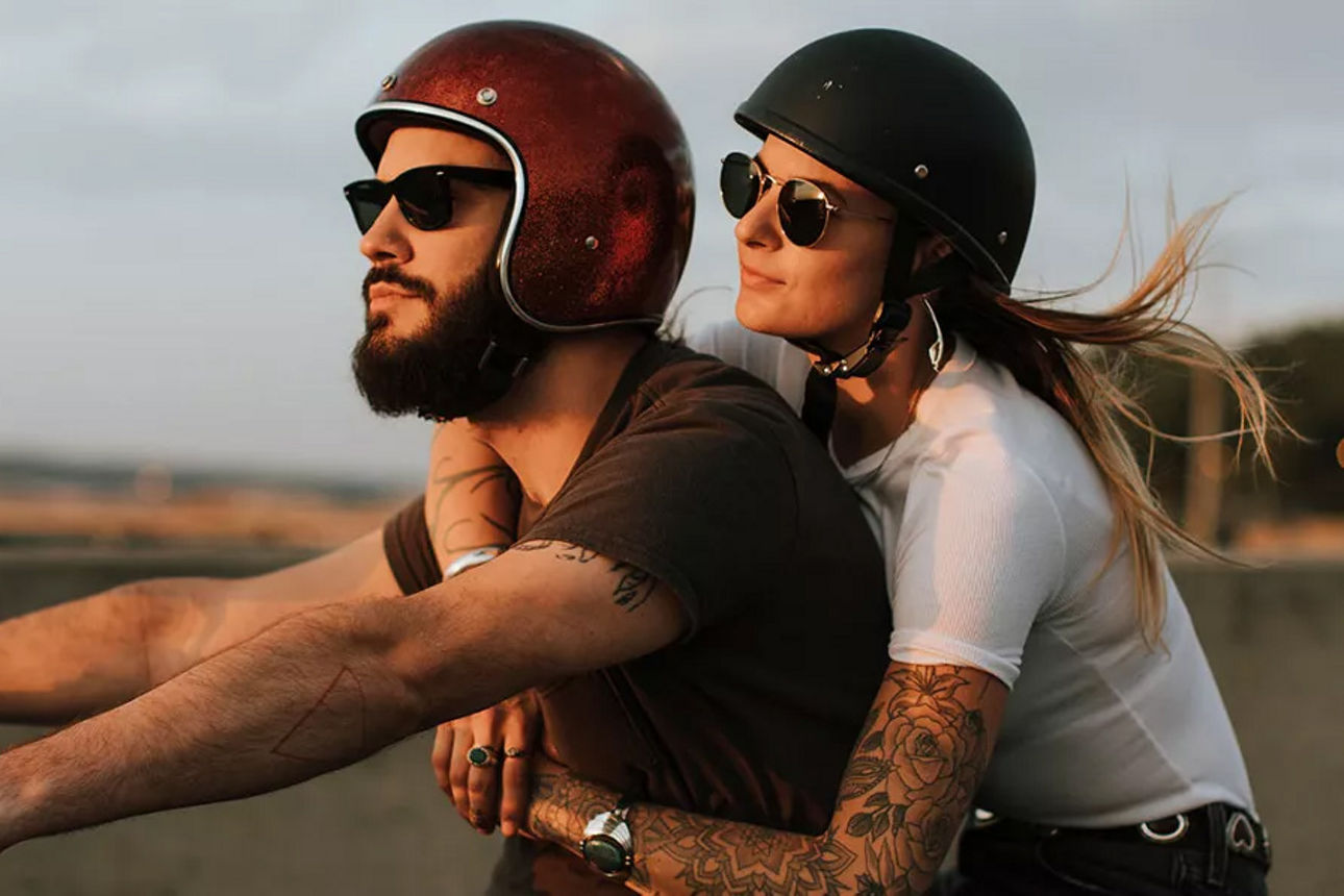 Junges Paar im Fahrtwind auf dem Motorrad