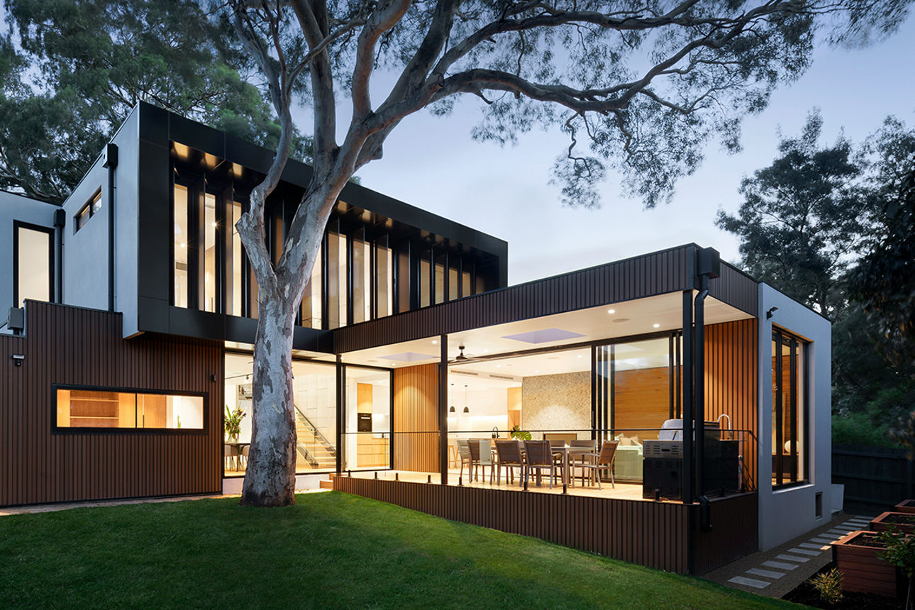 Zwei Personen schauen in ein Modellhaus