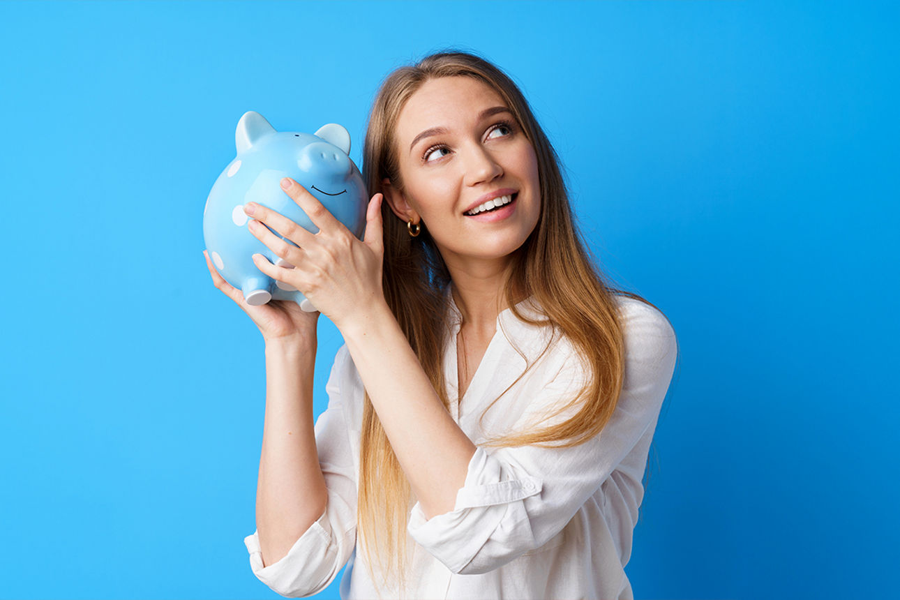 Eine junge Frau mit einem blauen Sparschwein