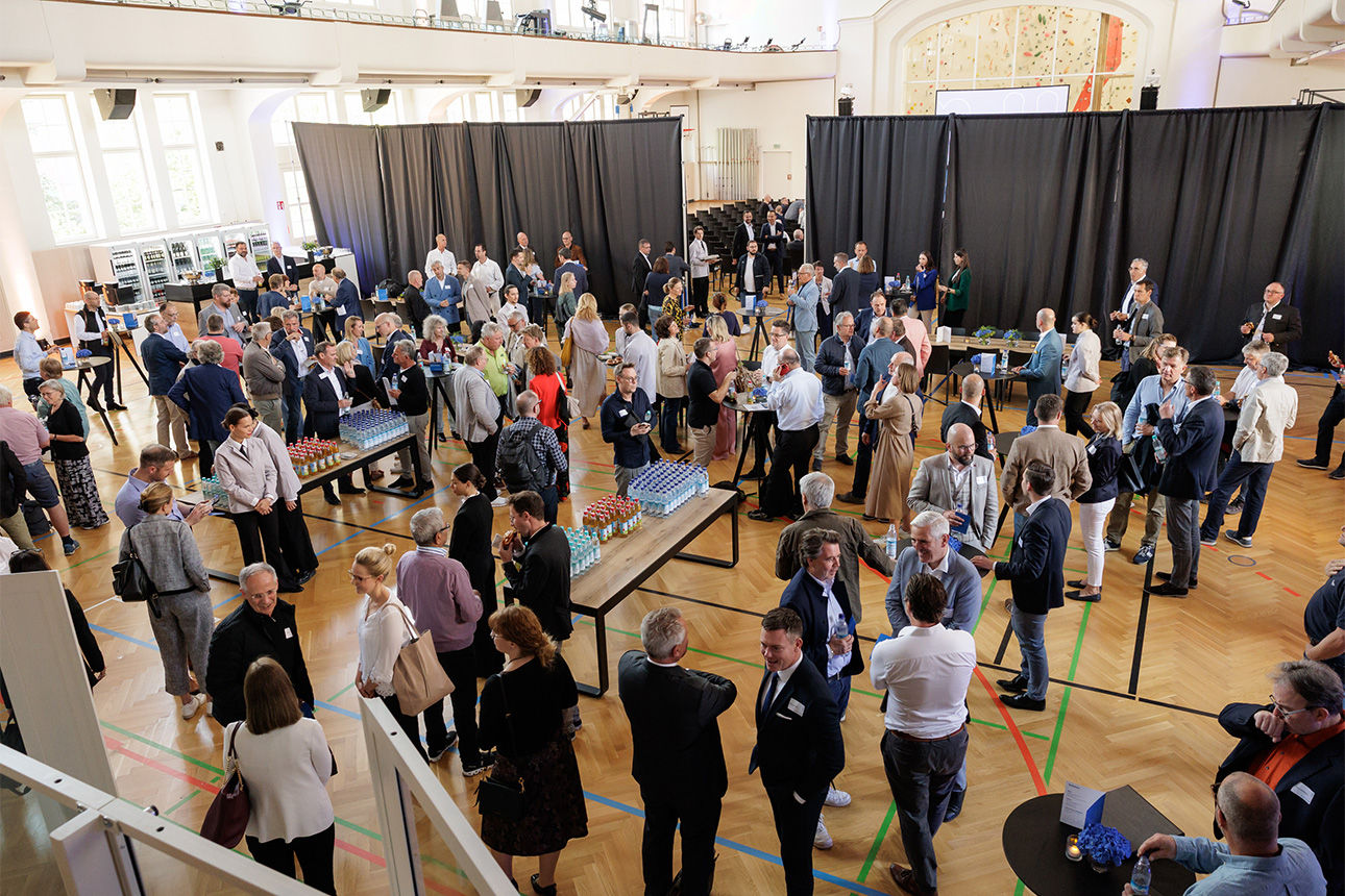 Zahlreiche Personen in einer Jugendstil-Sporthalle