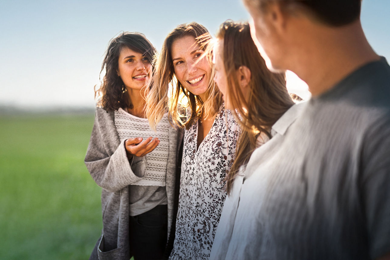 Vier Menschen stehen auf einem Feld