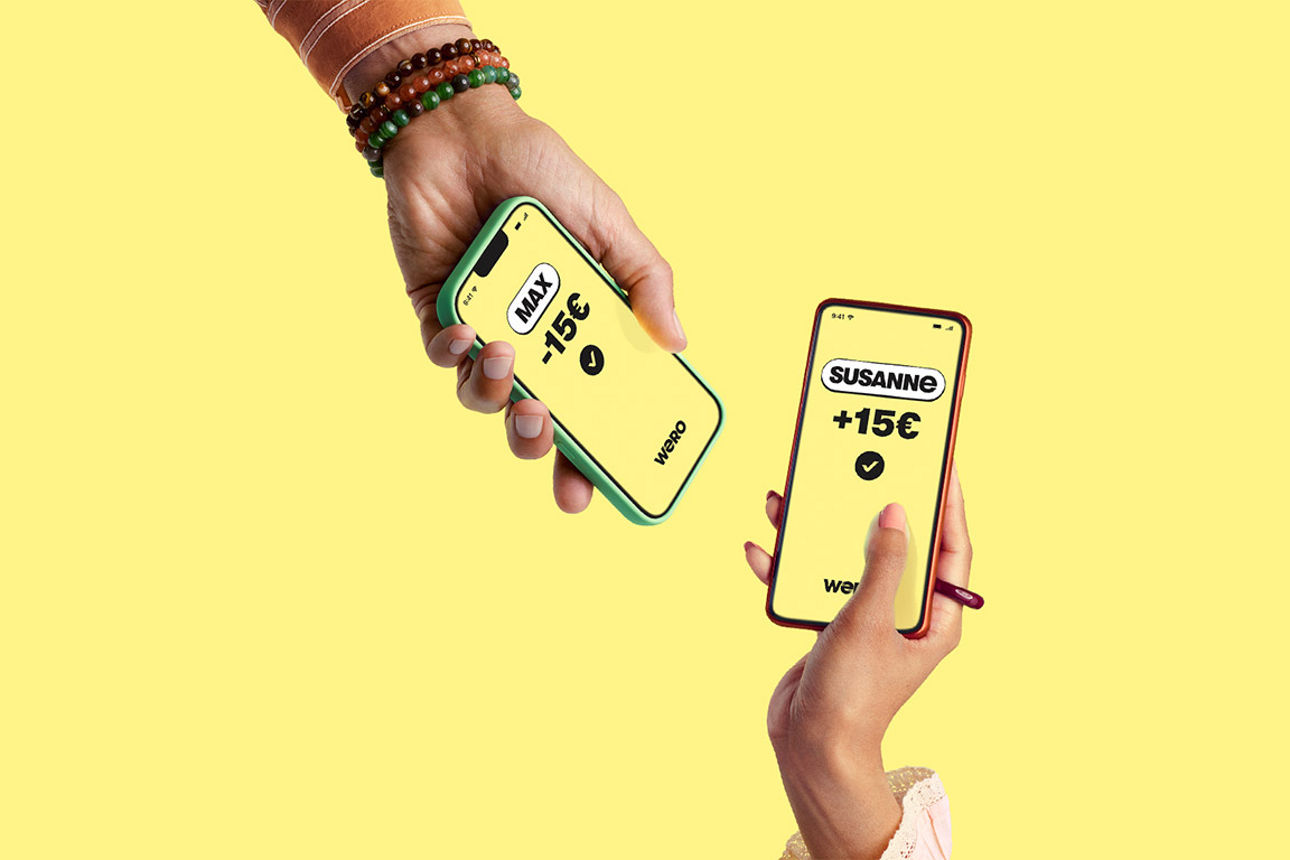 Zwei Hände halten zwei Handys aneinander - auf einem steht "Max -15 €", auf dem anderen Susanne +15 €