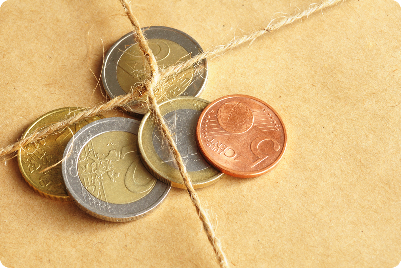 Verschiedene Euro-Münzen sind von einer Paketschnur eingebunden