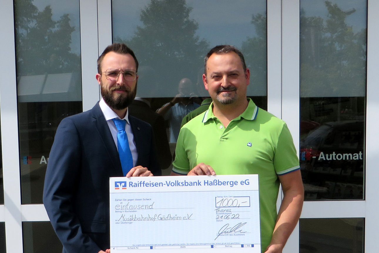 Tobias Müller, Filialleiter Theres übergibt einen Spendenscheck an den Musikbahnhof Gädheim e. V.